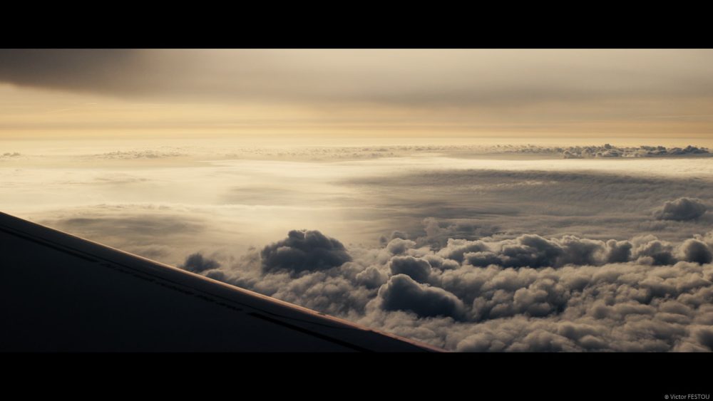 View from the airplane seat, golden clouds at dusk graded